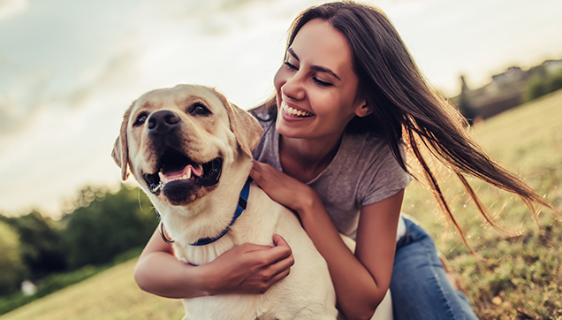 A woman playing with her dog outside