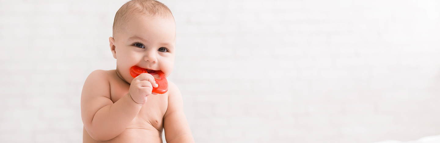 A toddler teething on a bracelet