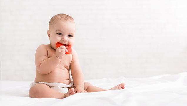 A toddler teething on a bracelet
