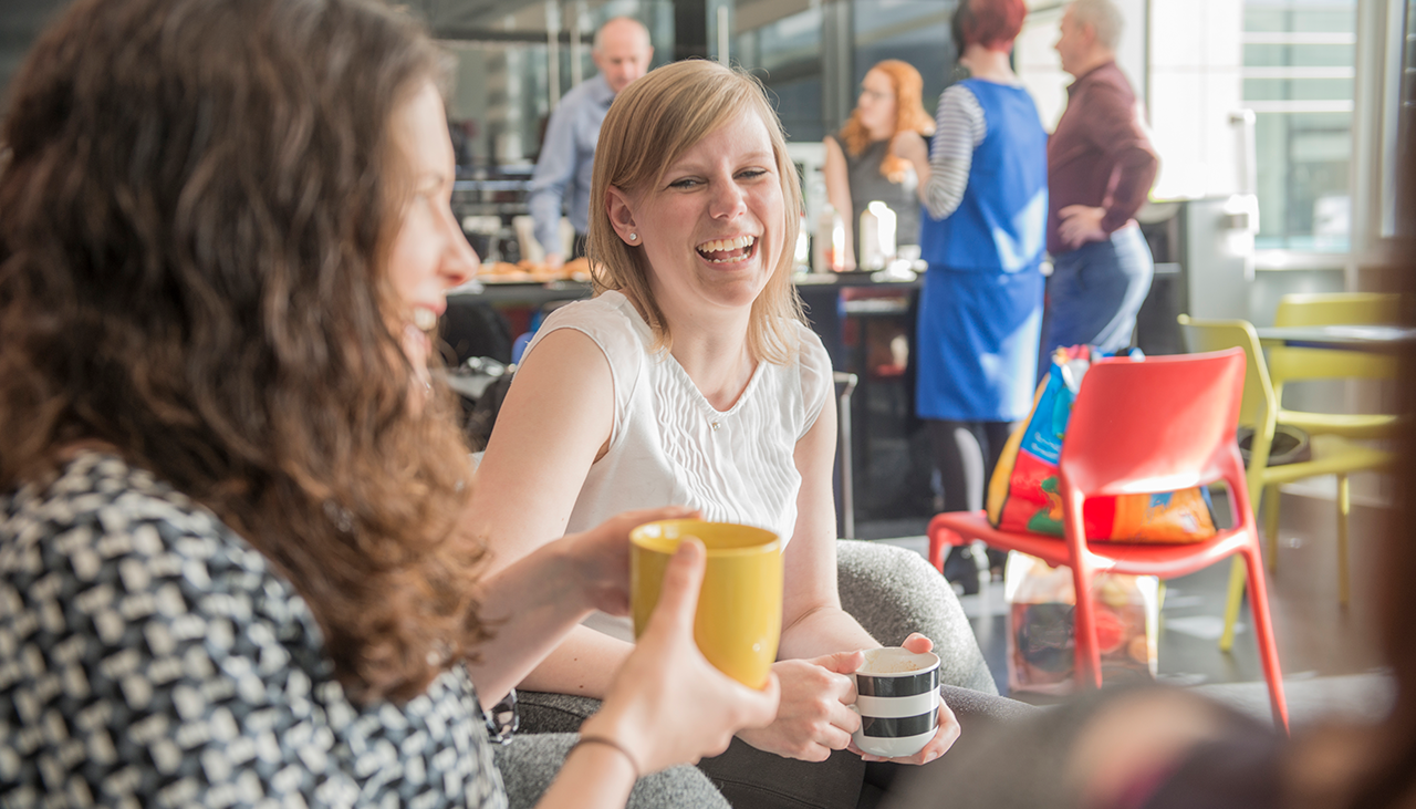 A group of people having a snack in a breakroom
