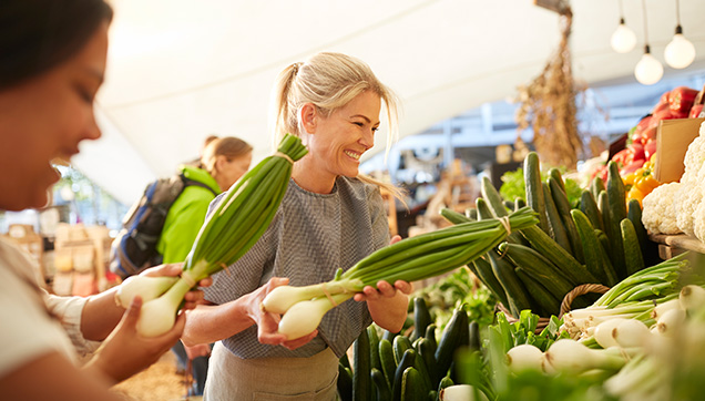 A woman buying vegetables at a market