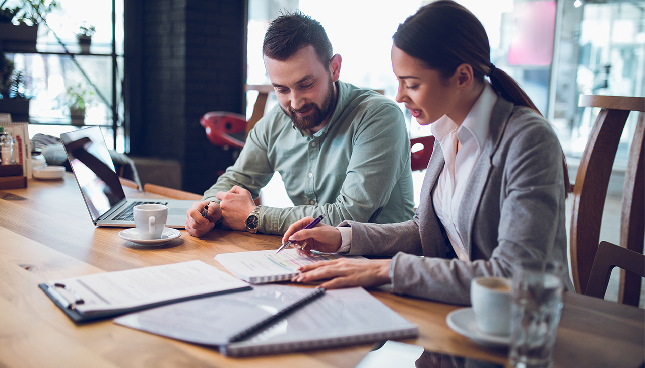 Two employees working together at a desk