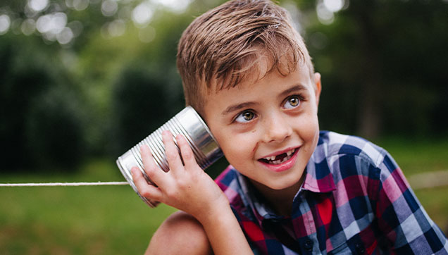 A child listening to a tin can telephone