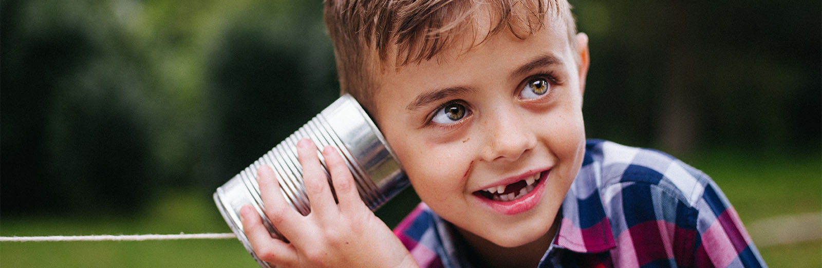 A child listening to a tin can telephone