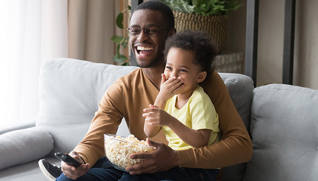 A father and son watching tv and laughing