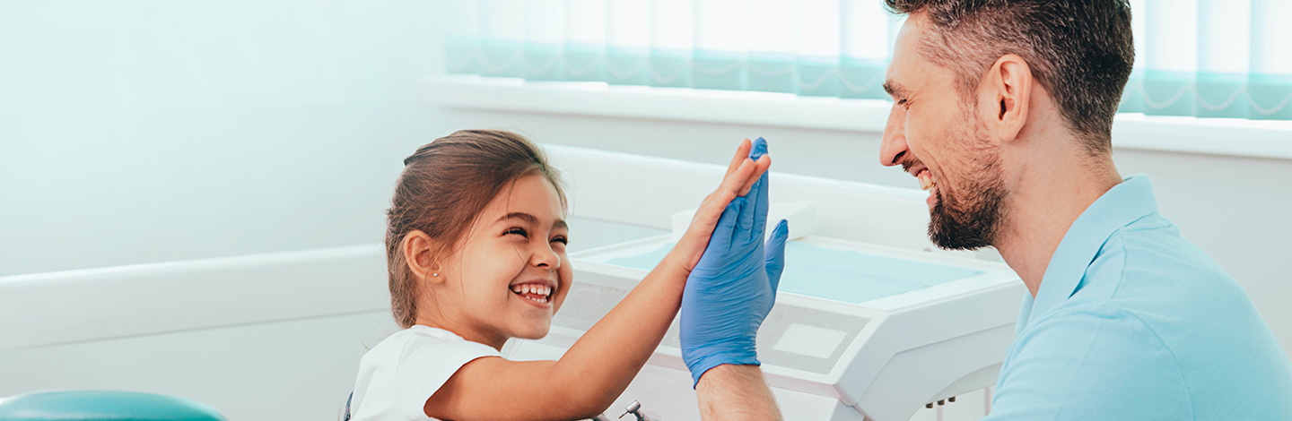 A dentist giving a small child a high five