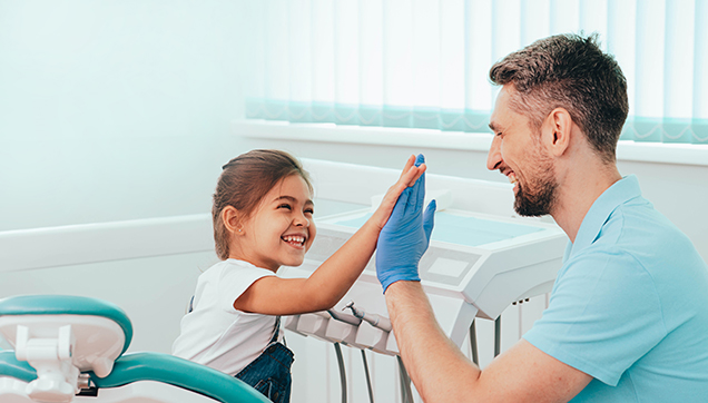 A dentist giving a small child a high five