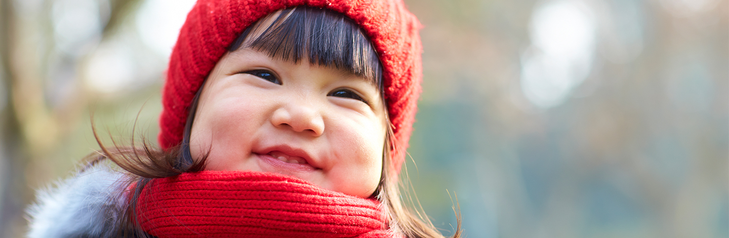 A toddler smiling with teeth shown