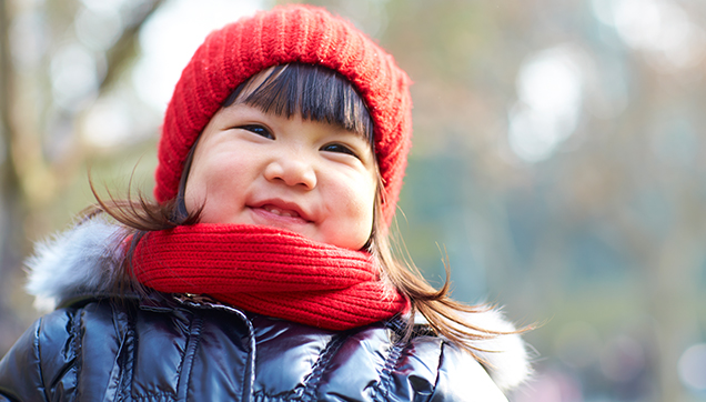 A toddler smiling with teeth shown