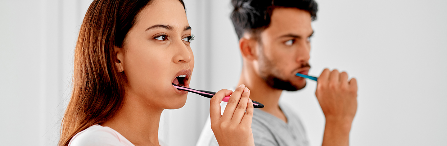 A couple brushing their teeth together