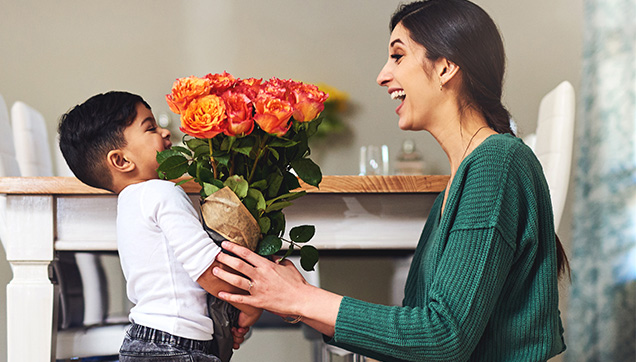 A child giving his mother flowers
