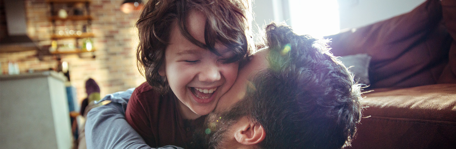 A father and son laughing in their living room