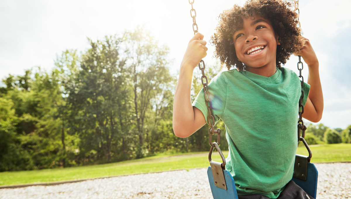 A child swinging and smiling