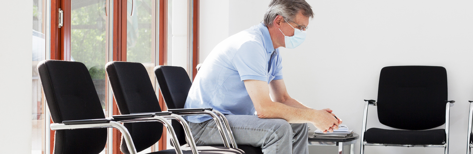 A man sitting in a dentist lobby with anxiety 