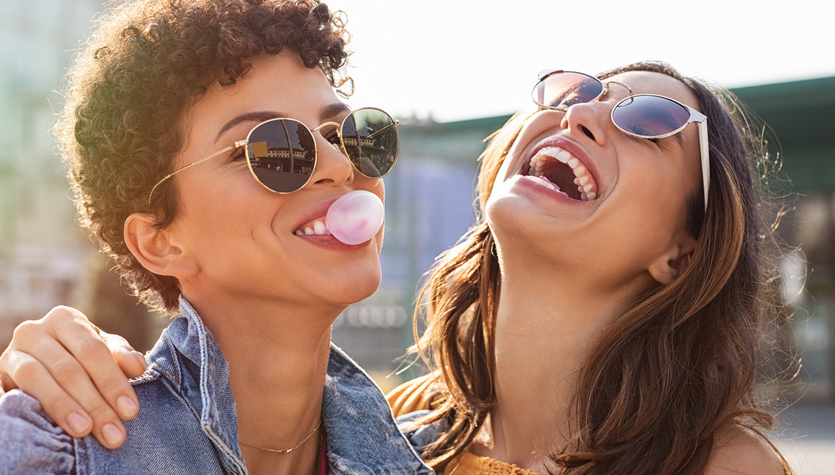 Two woman laughing and blowing gum bubbles 