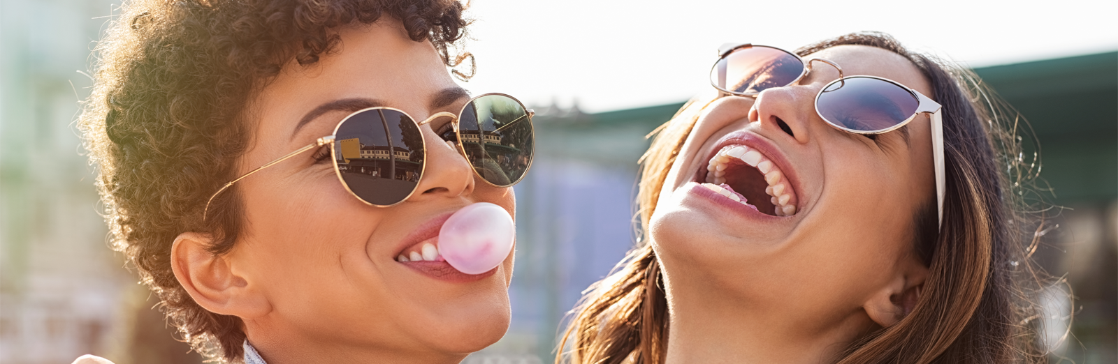 Two woman laughing and blowing gum bubbles 