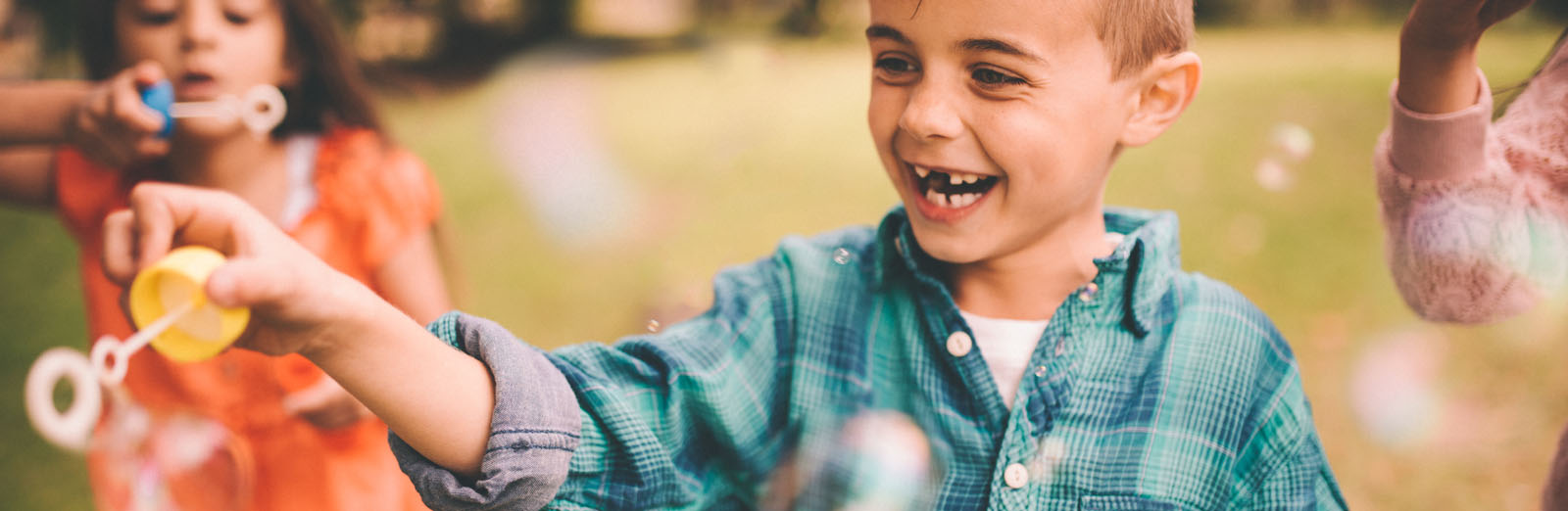Two children blowing bubbles outside