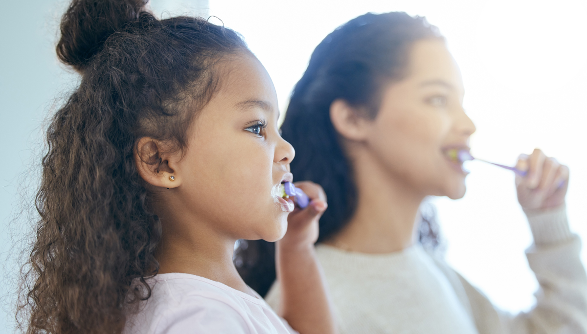 A mother and daughter brushing their teeth