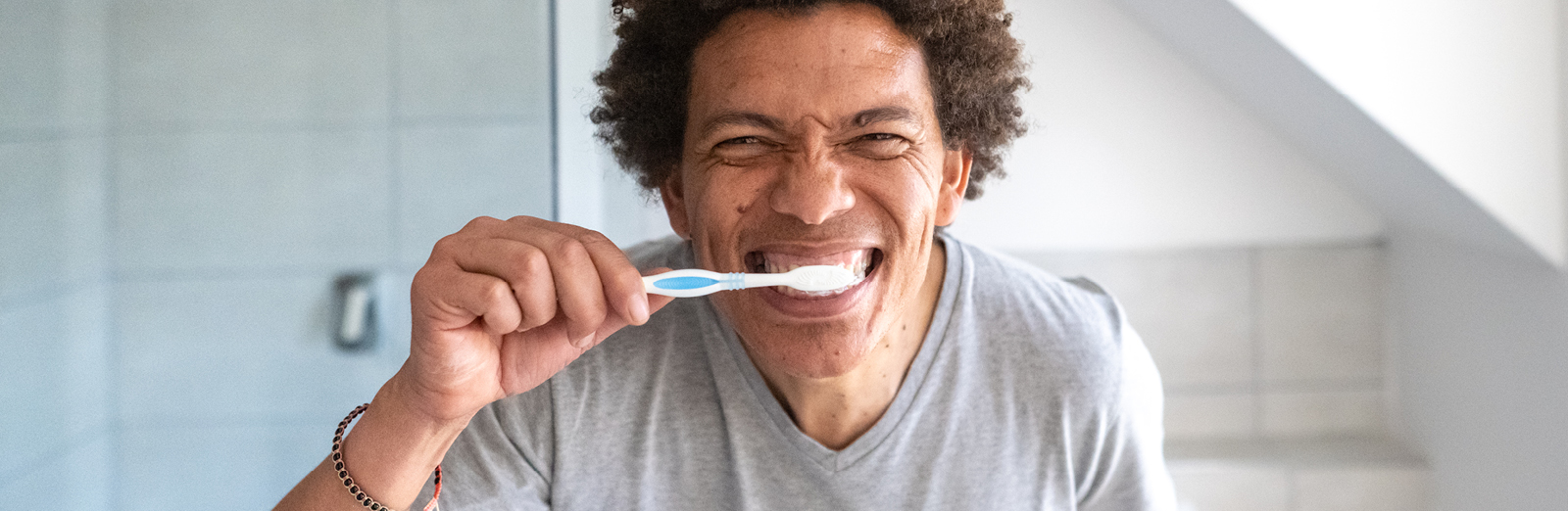 A man brushing his teeth in a mirror