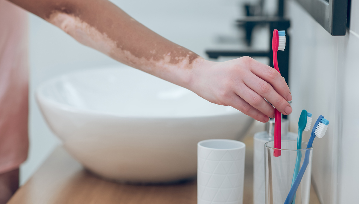 A person putting a toothbrush away