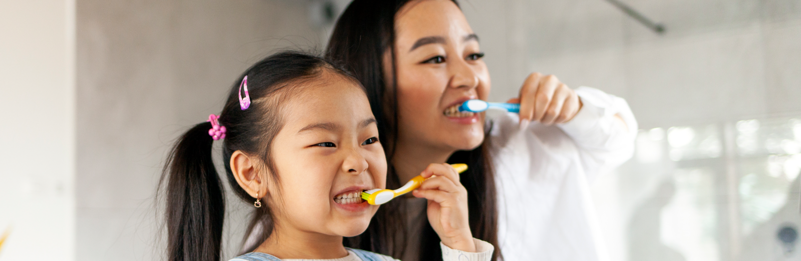 mom-and-daughter-brushing-their-teeth-1600x522.png