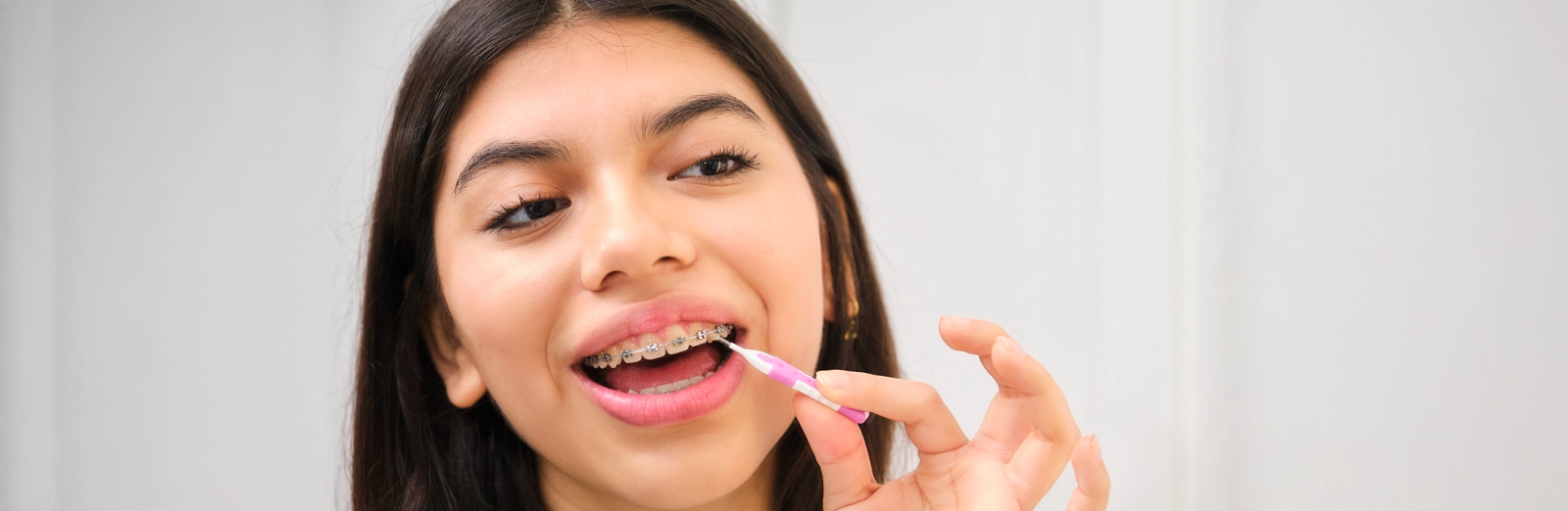 girl-cleaning-her-braces-1600x522.webp