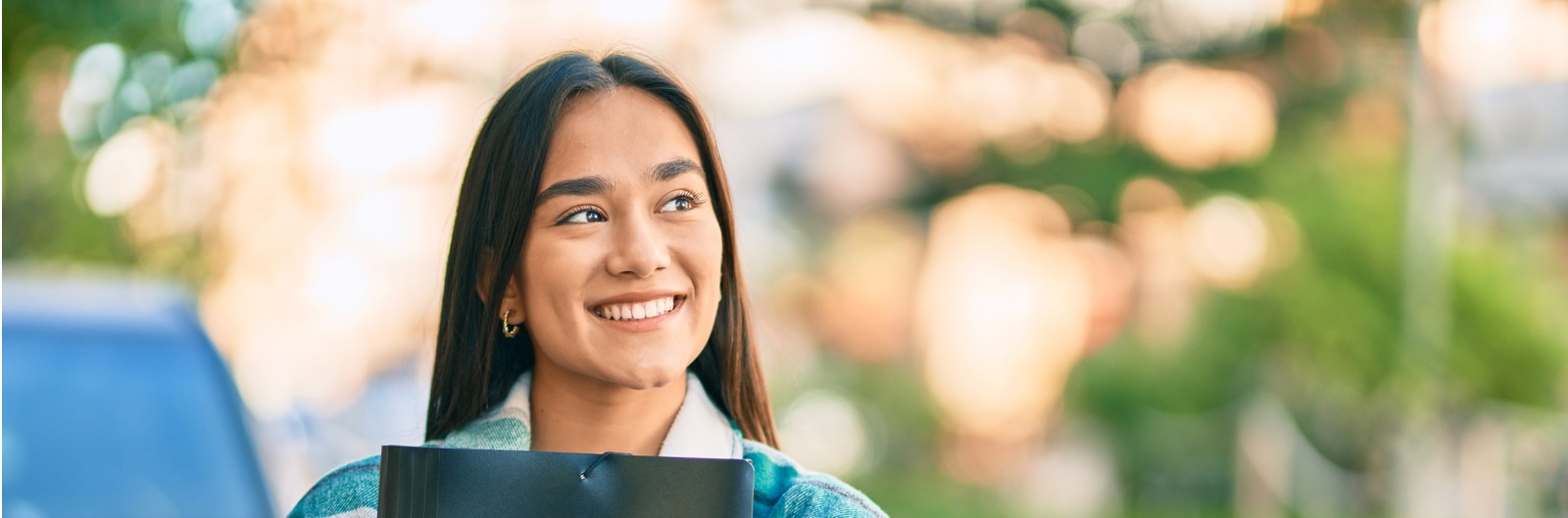 A girl carrying books and smiling