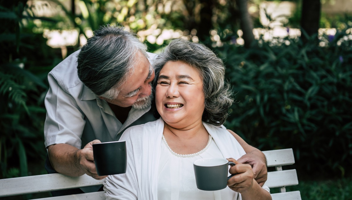 A couple sitting in a park drinking coffee