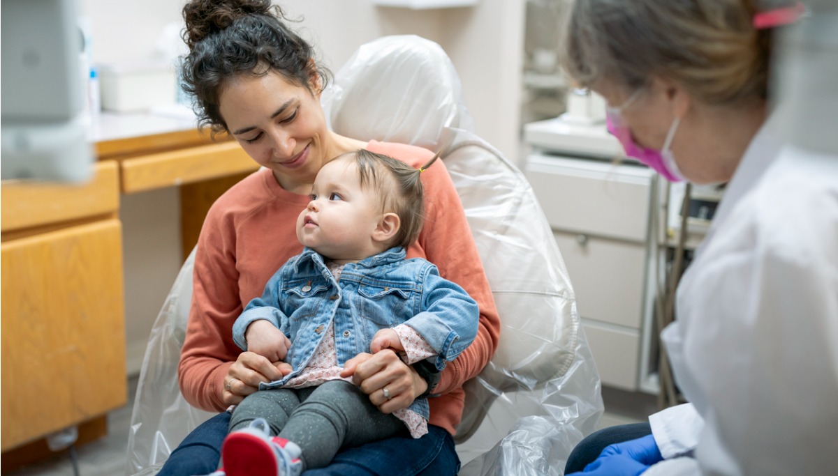 A mother and toddler sitting with a dentist