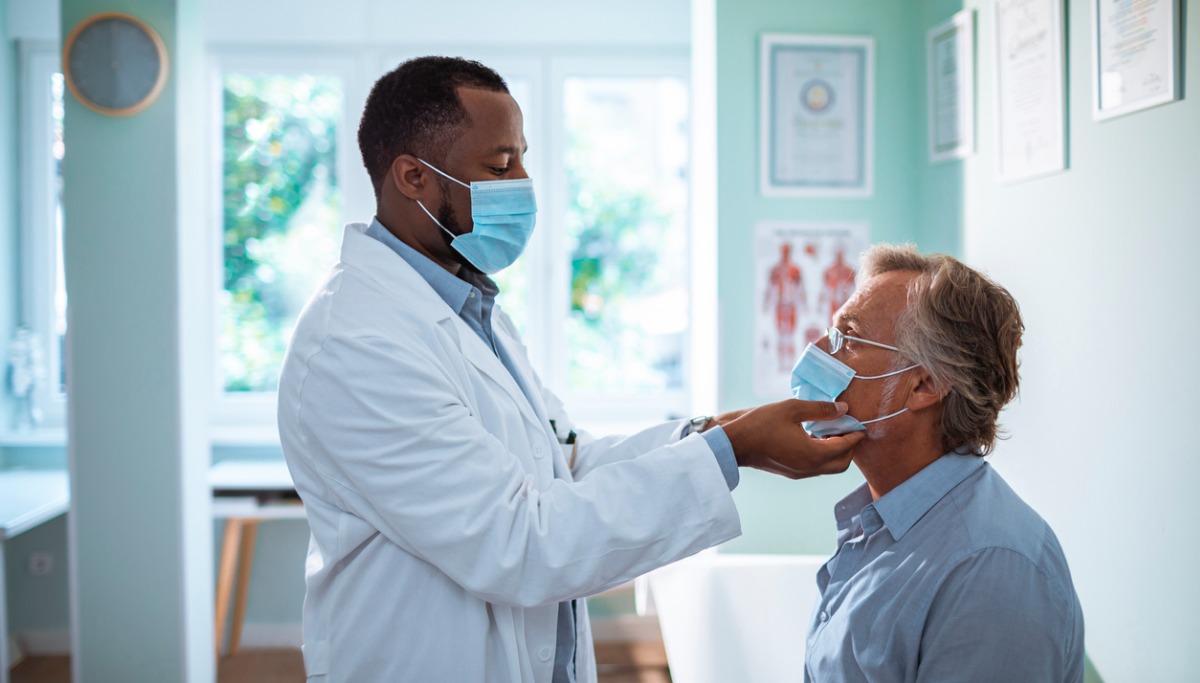 A dentist examining the jaw of a patient