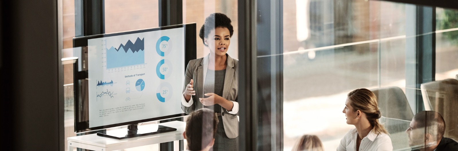 A woman presenting graphs to a group of people