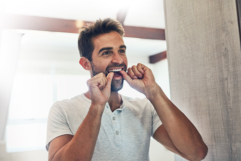  A man flossing this teeth
