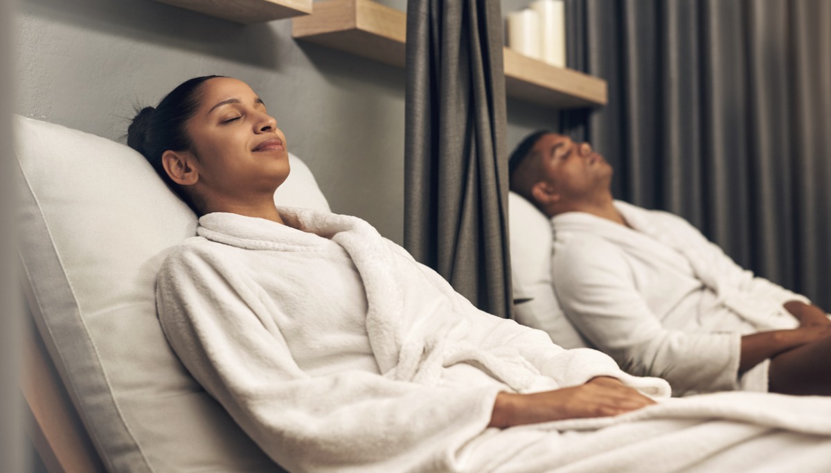 A couple relaxing at a spa with their eyes closed