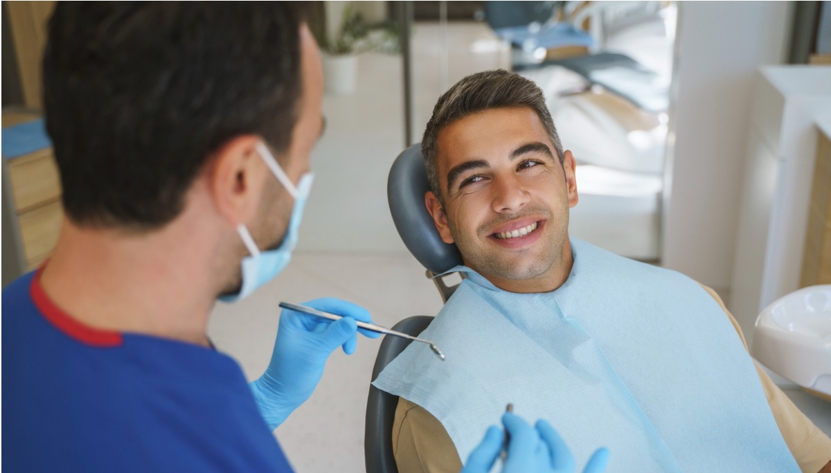 A patient looking up and smiling at a dentist