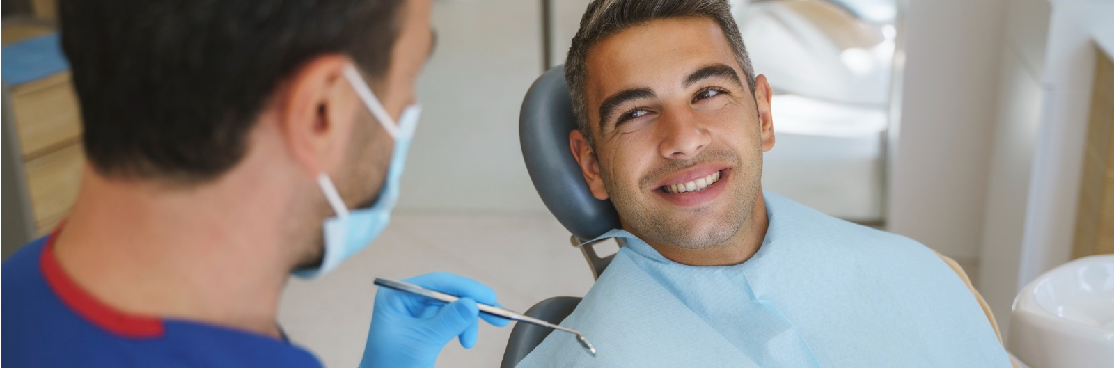 A patient looking up and smiling at a dentist