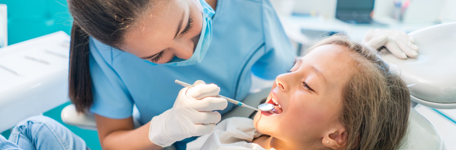 A dentist conducting an exam on a young patient