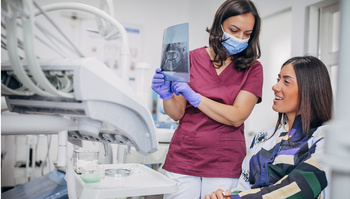 A dentist showing a patient a tooth x-ray