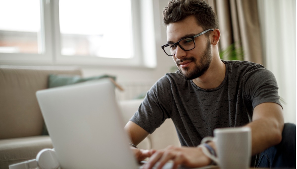 A man with glasses using a laptop.