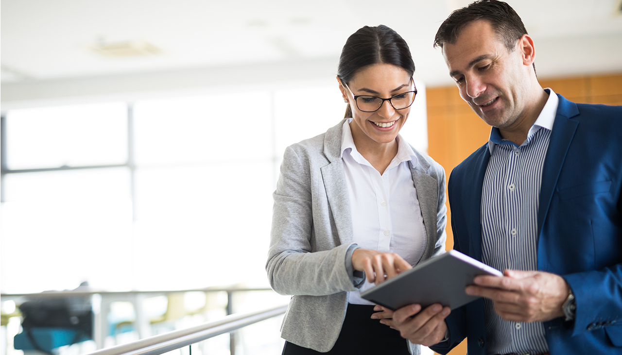 Two coworkers looking at a tablet computer