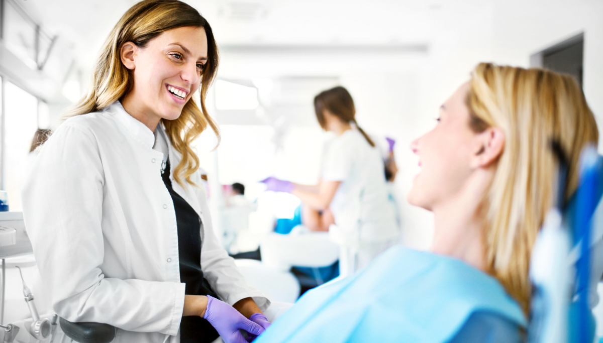 A dentist talking with a patient in a office