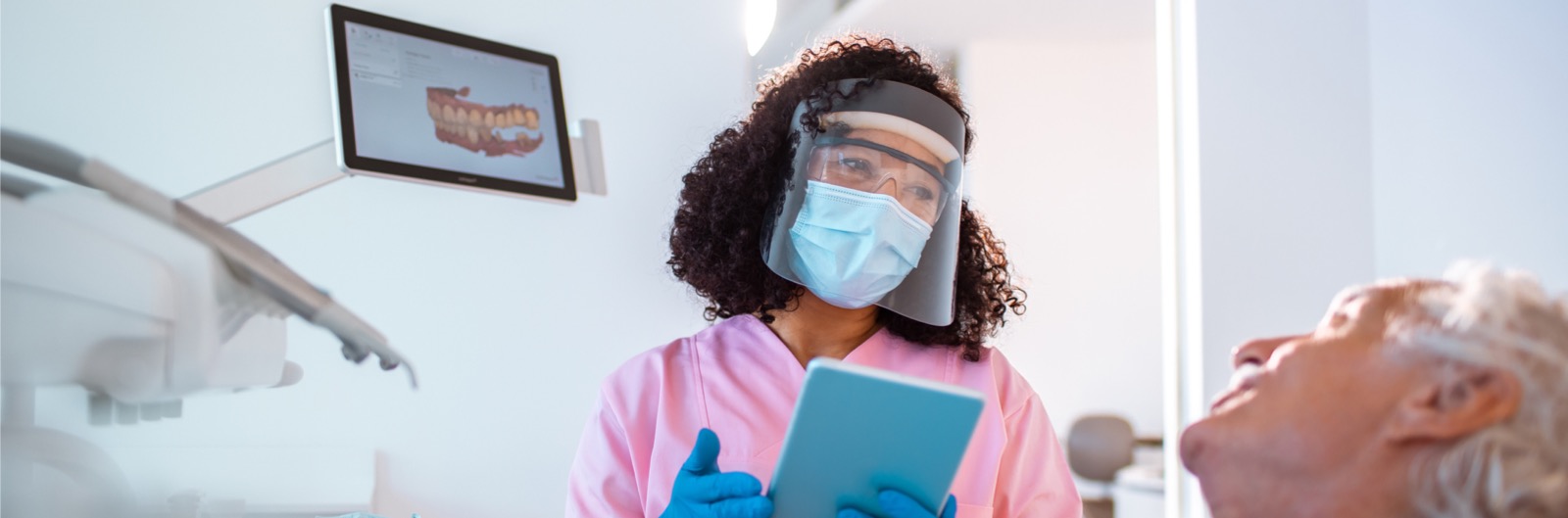 A dentist showing a patient a diagram of a mouth