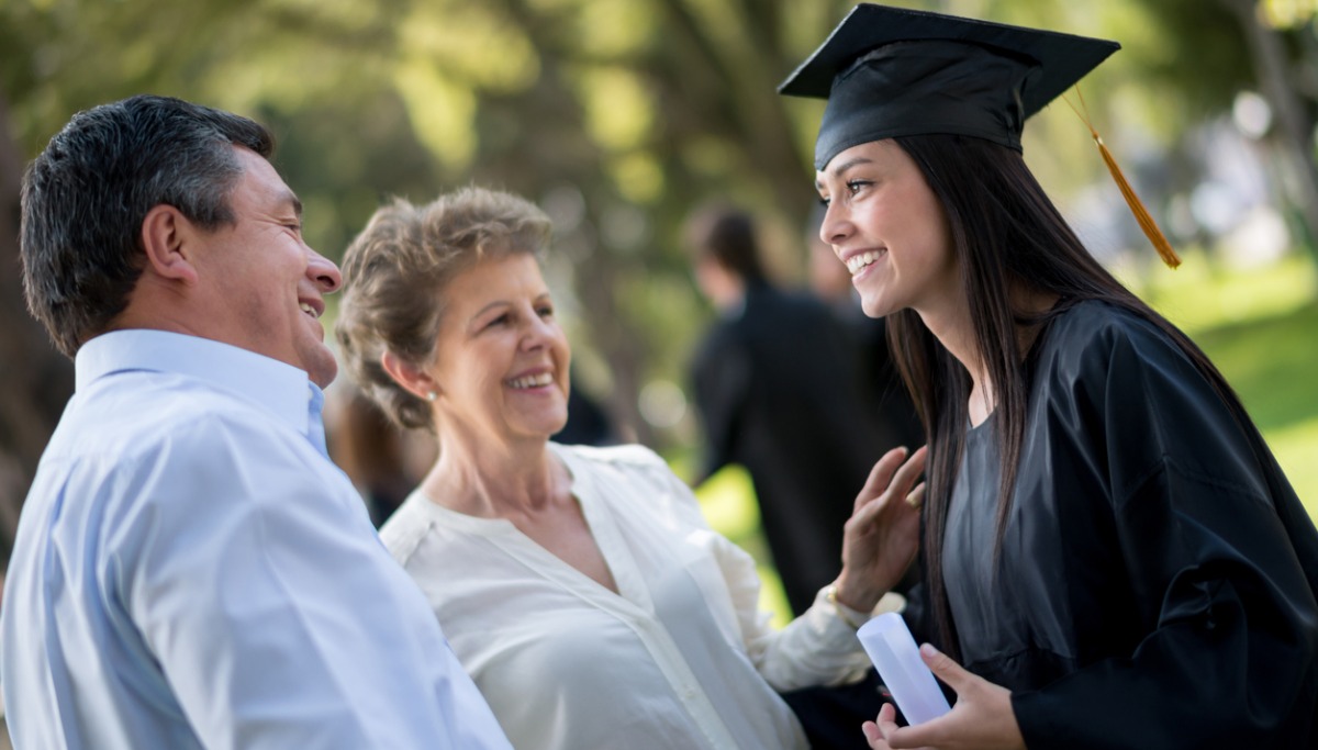 A young woman who just graduated is celebrating with her family.