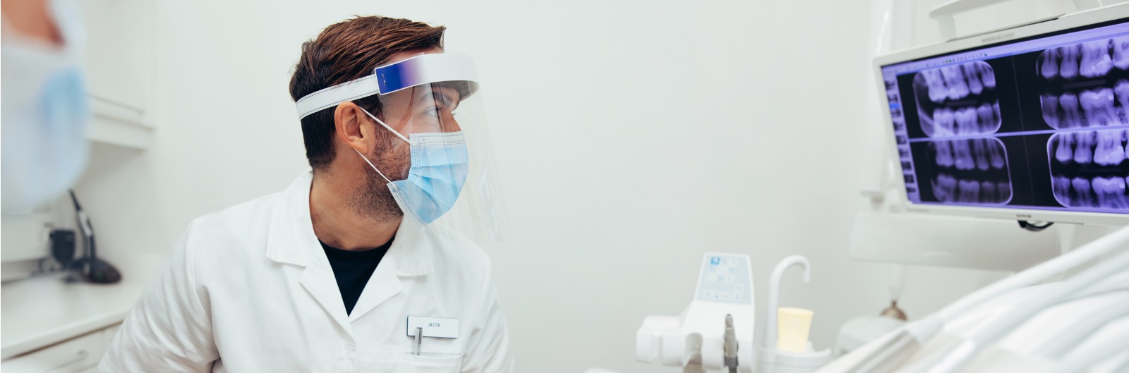 A dentist looking at x rays of a mouth