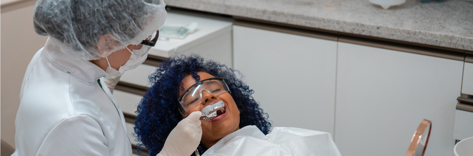 A dentist creating a mold of a patient's teeth