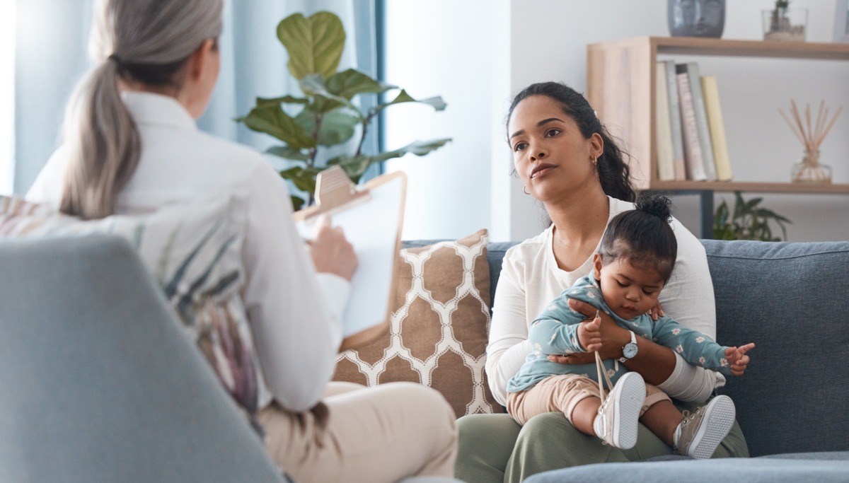 A woman consulting a mother and baby