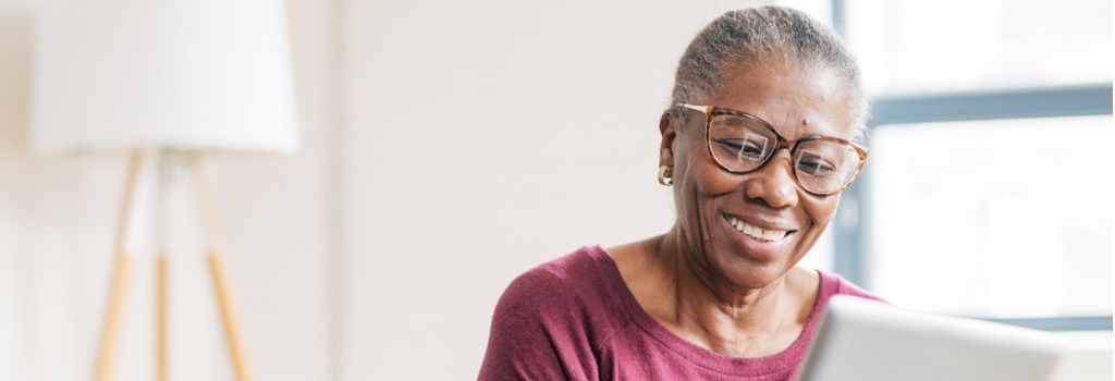 A woman sitting at a computer looking at dental coverage.