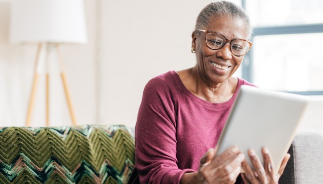 A woman sitting at a computer looking at dental coverage.