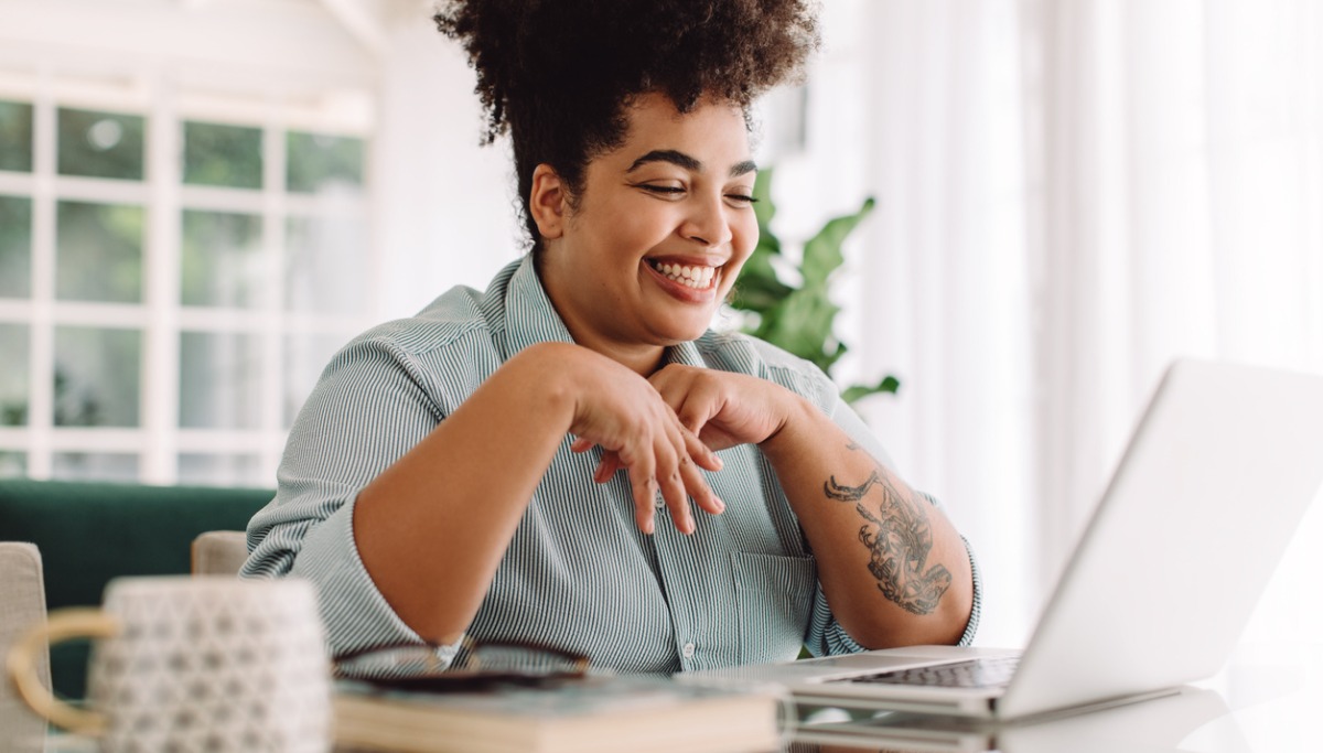 A woman using a laptop and smiling