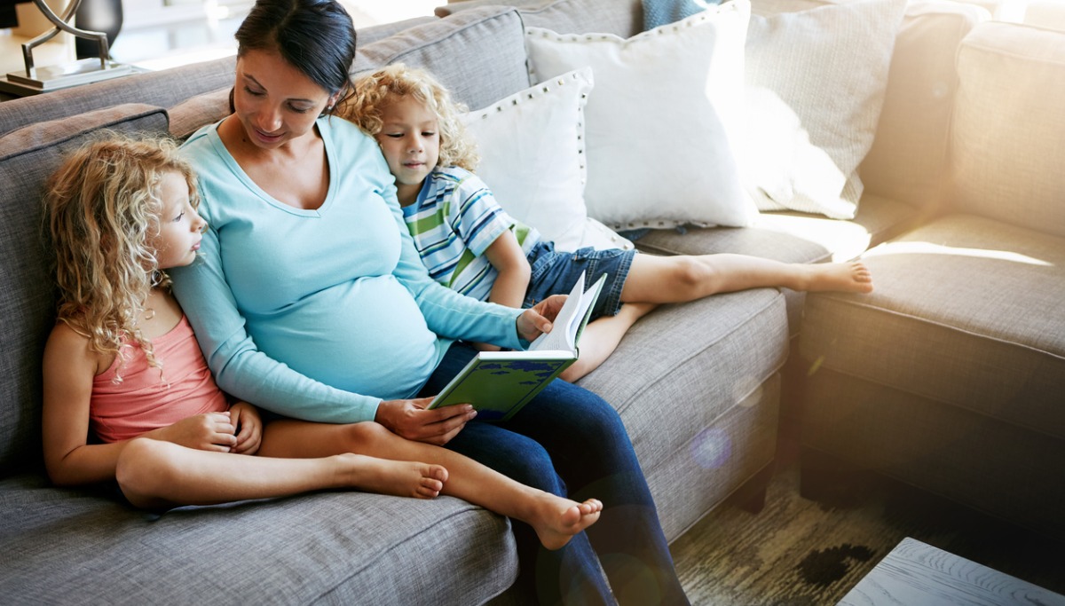 A mother reading a book to two young children