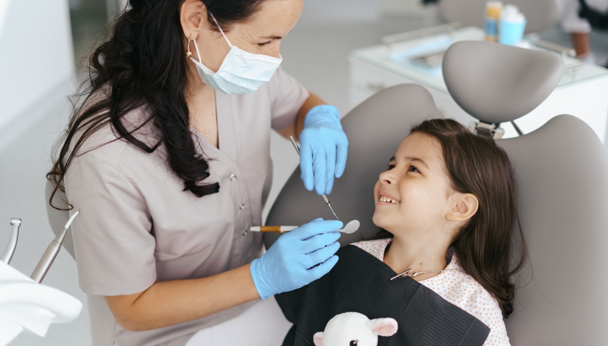 A dentist conducting an exam on a young girl